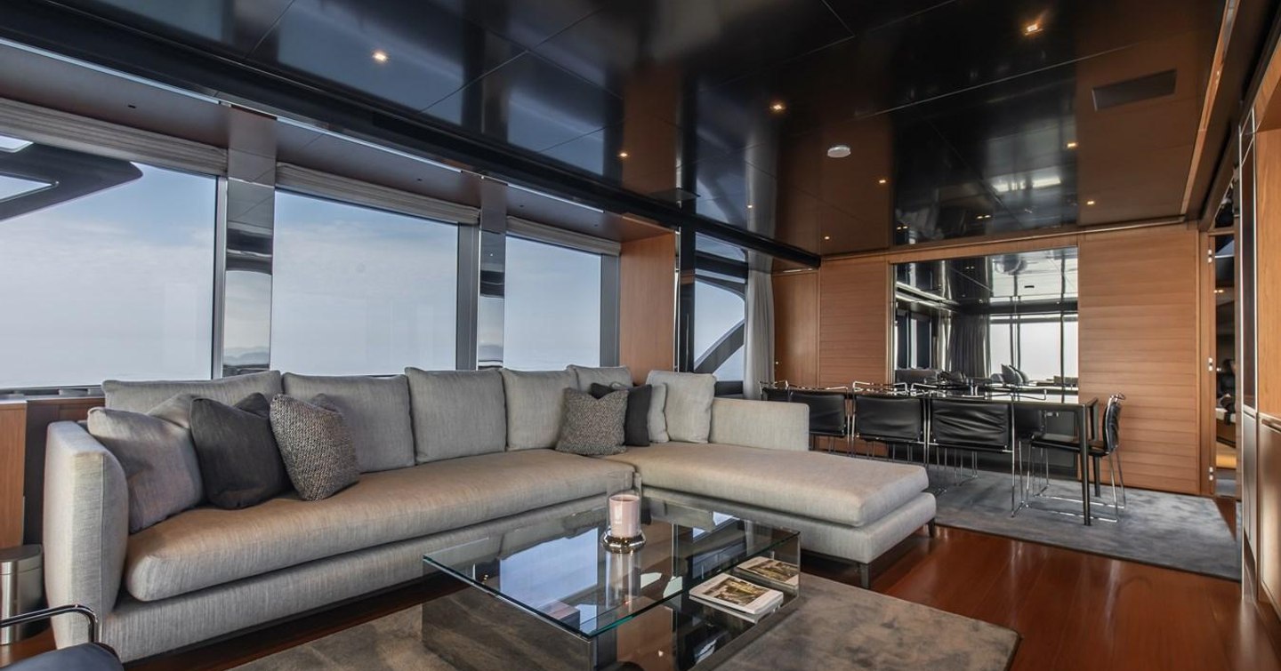 Motor Yacht T57's main saloon with L-shaped sofa and dining area