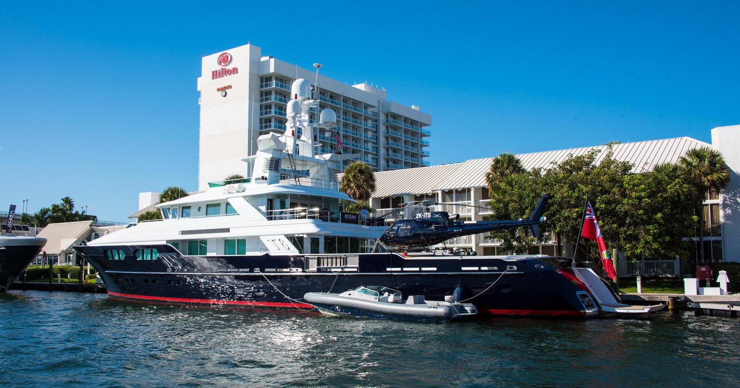 Superyacht berthed with adjacent tender outside Hilton hotel in Fort Lauderdale.