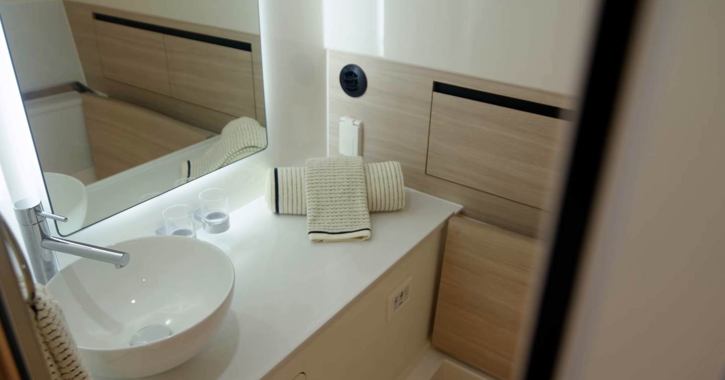 Aquila 45 Sport bathroom vanity with sink, mirror and storage, showing clean wet head layout below deck