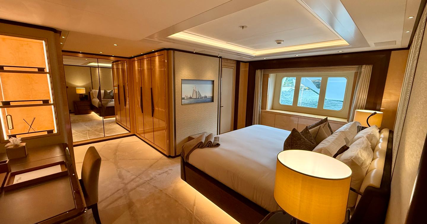 Lower deck guest cabin on the Amels 242 Casino Royale featuring a double bed, desk area and hull windows with sea views.