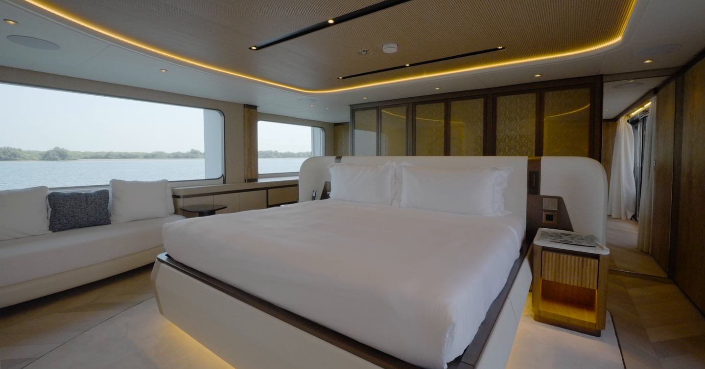 Full-beam owner's suite aboard the Gulf Craft Majesty 145 with king-size bed and hull windows