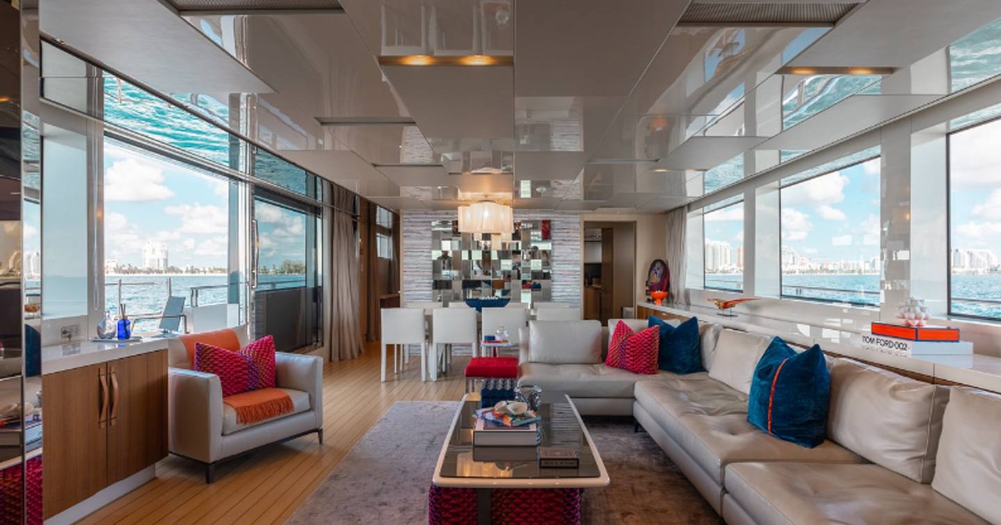 Main saloon on motor yacht Fifty Shades with L-shaped sofa and colourful cushions along with dining area