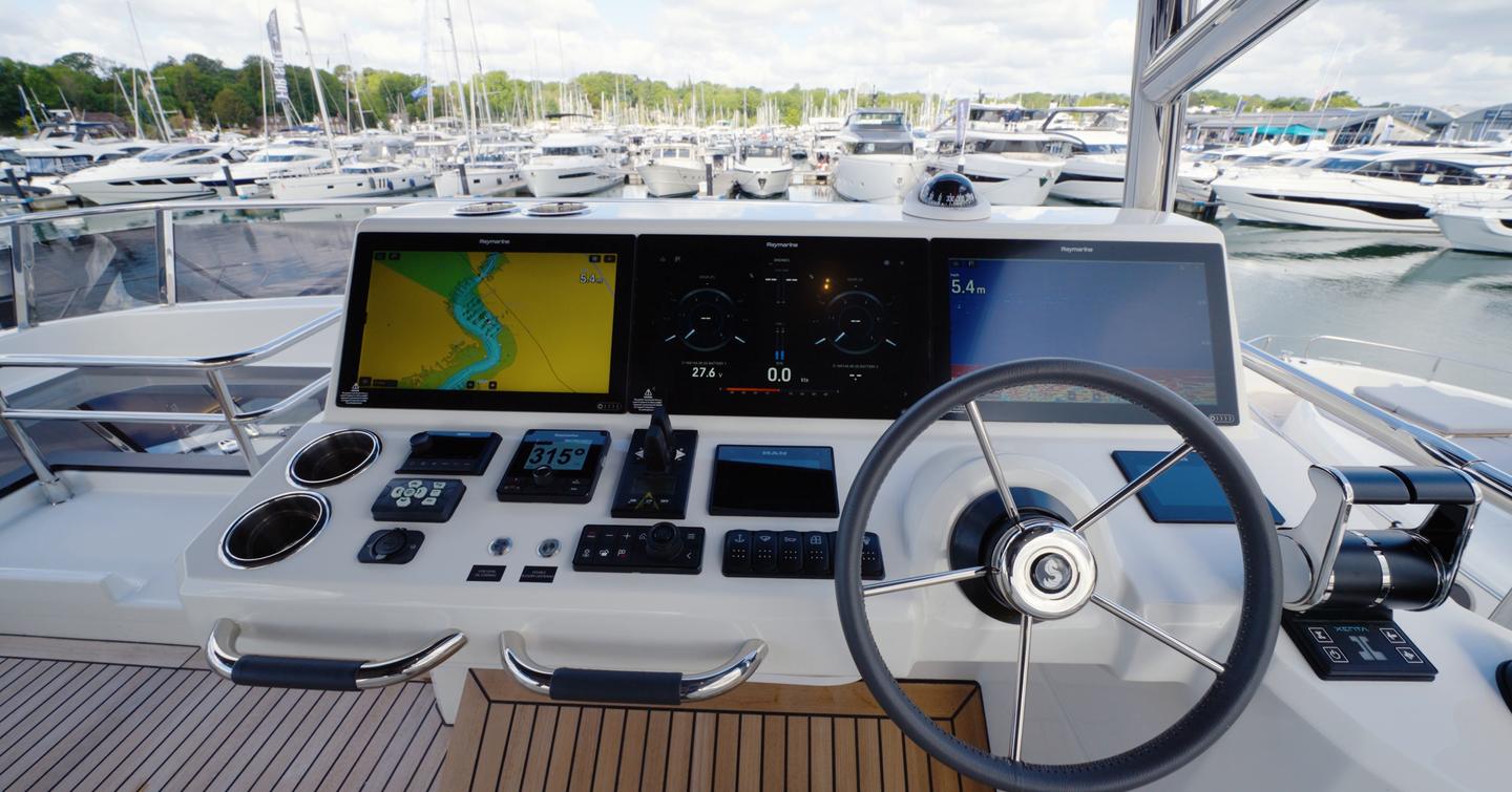 Beneteau Grand Trawler 63 flybridge helm with triple Raymarine displays and engine controls