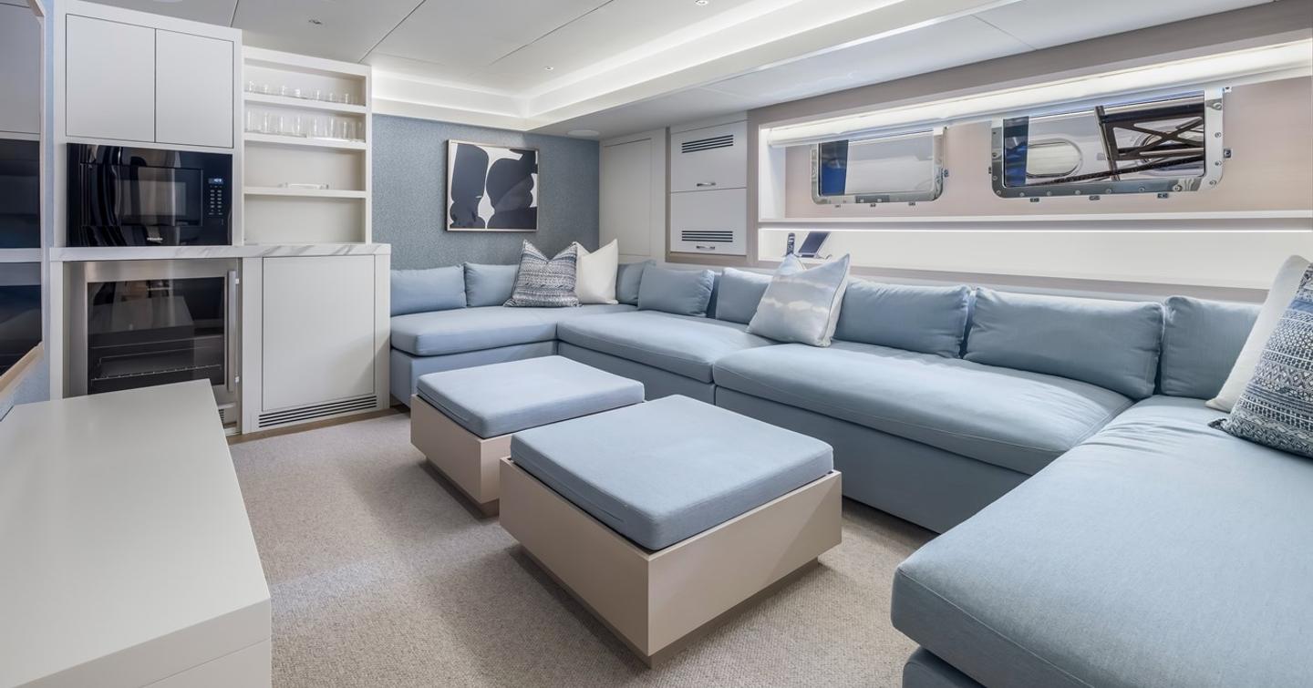 Superyacht Evelyn P's indoor cinema room with u-shaped blue seating