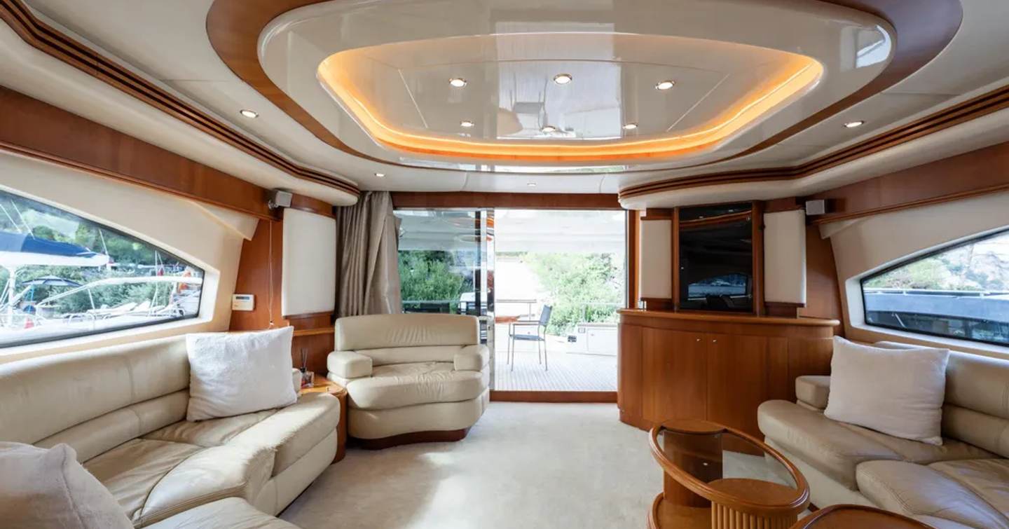 Motor yacht Senior S main saloon with curved seating and mounted TV