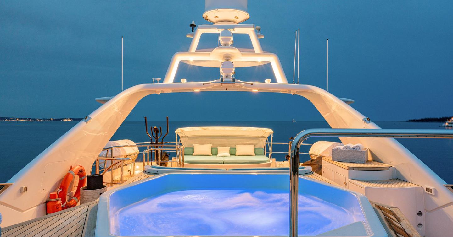 Superyacht Bang! sundeck with lit up jacuzzi and aft sunbeds 