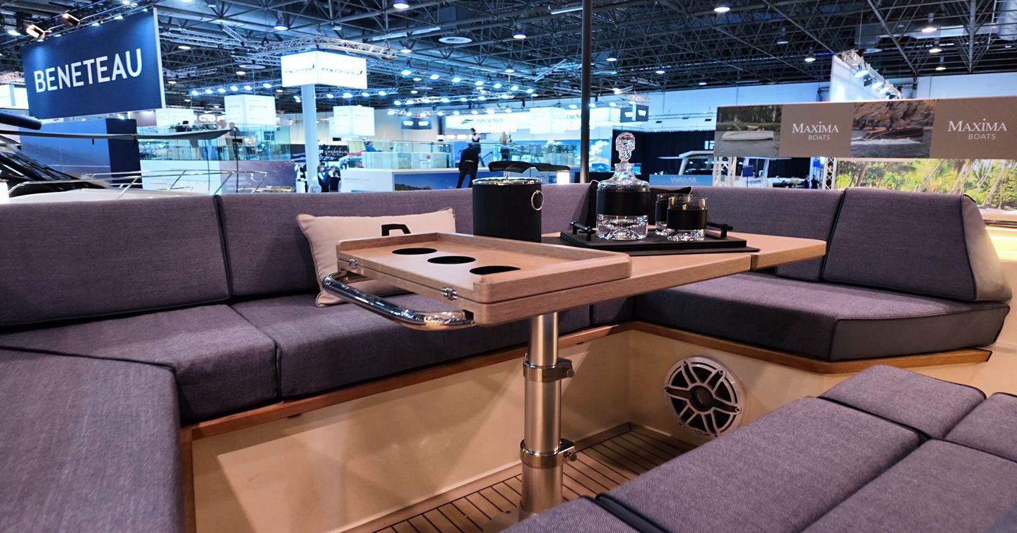 Foredeck dining area on the Aiata Sunfinder 50 with U-shaped seating, adjustable teak table with cup holders and wide bow platform at the Düsseldorf Boat Show.