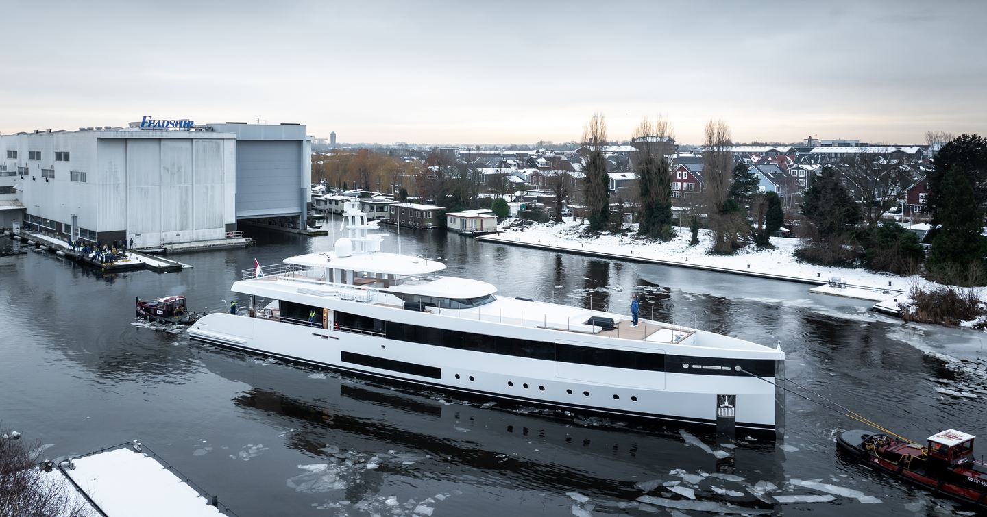Superyacht Project 717 being followed by a tugboat outside Feadship shipyard 