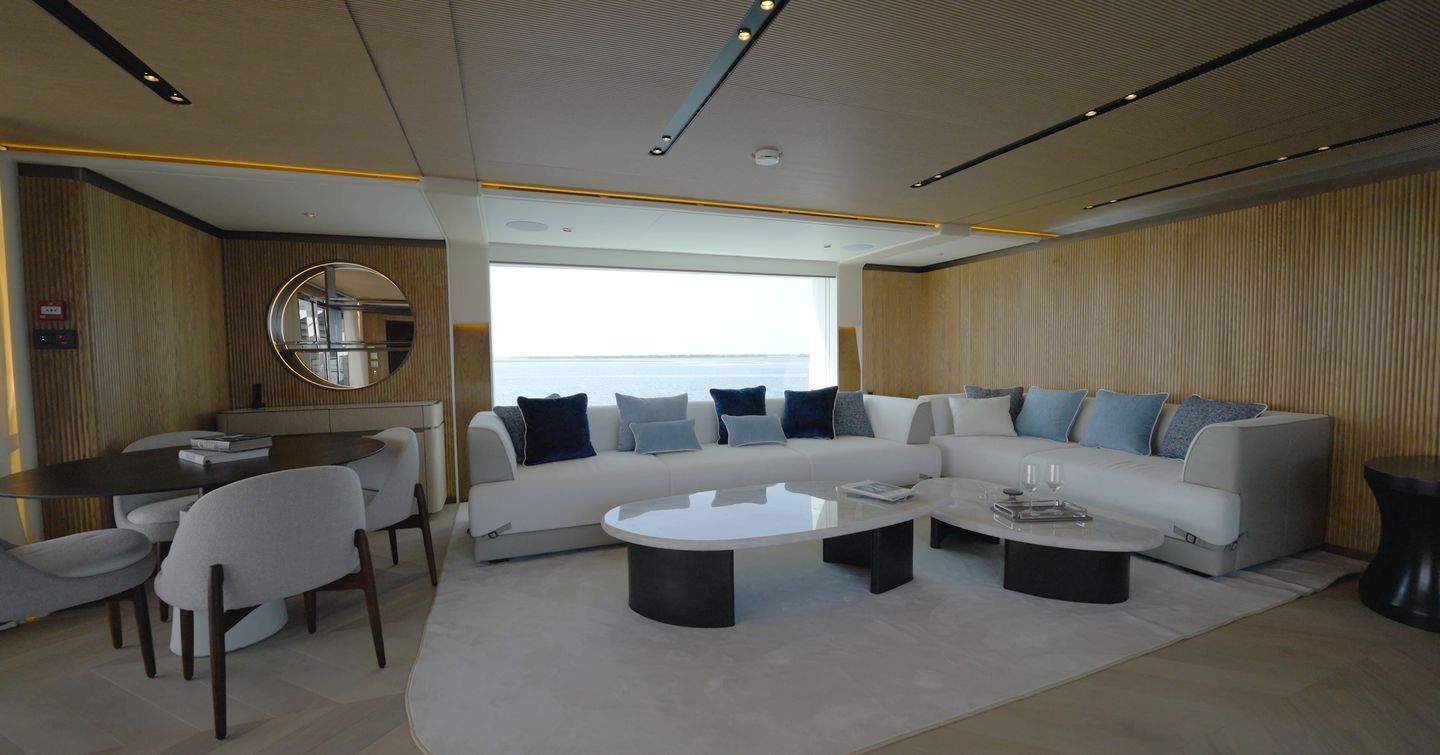 Gulf Craft Majesty 145 skylounge with curved lounge seating, dining area and panoramic windows