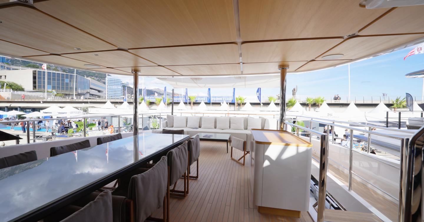 Custom Line Navetta 38 bridge deck aft with outdoor dining table, shaded seating and easy access to foredeck