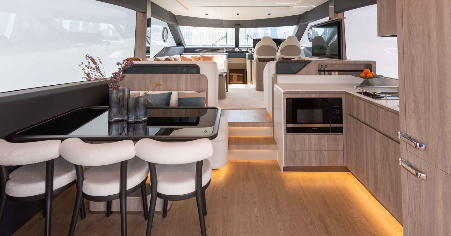 Majesty 60 Motor Yacht main saloon with black dining table and integrated white seating 
