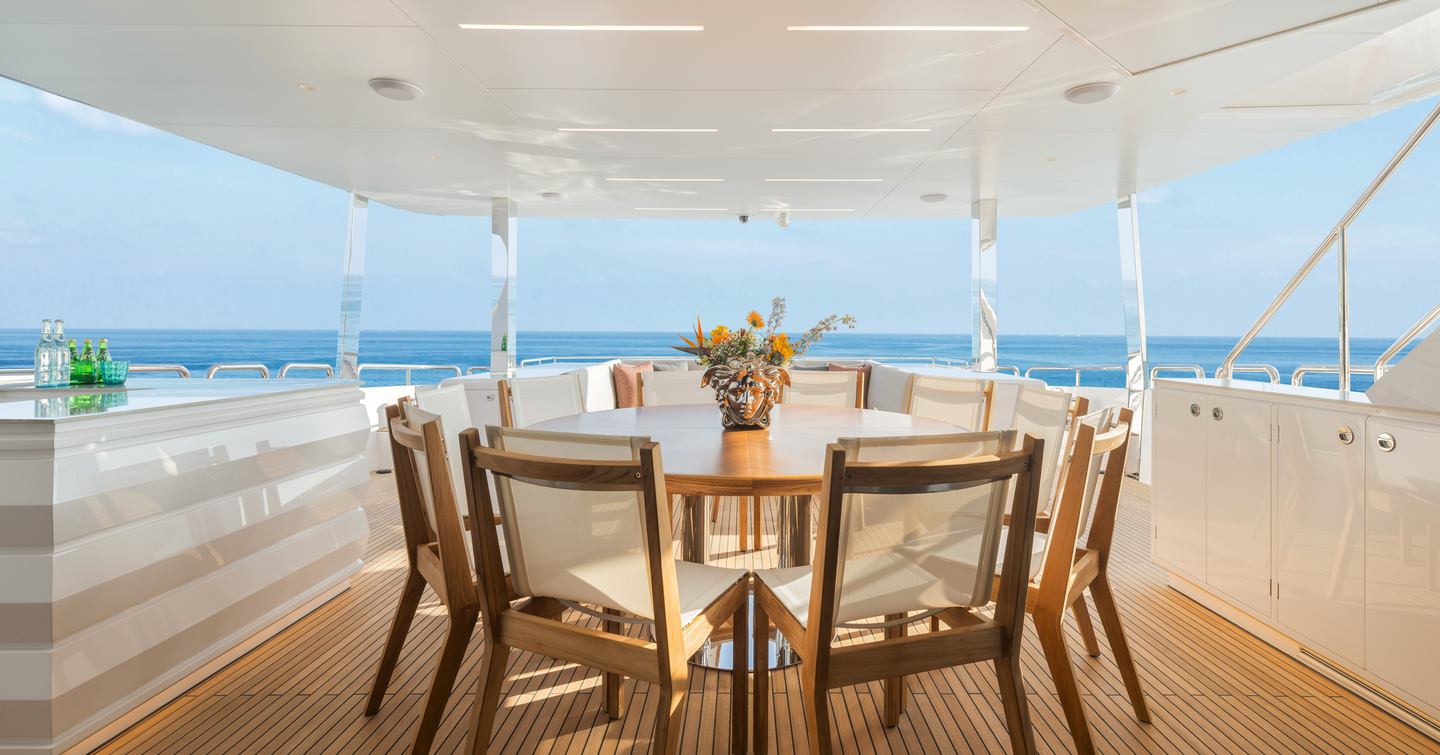 Seventh Horizon FD110 motor yacht main aft deck with circular shaded dining table 