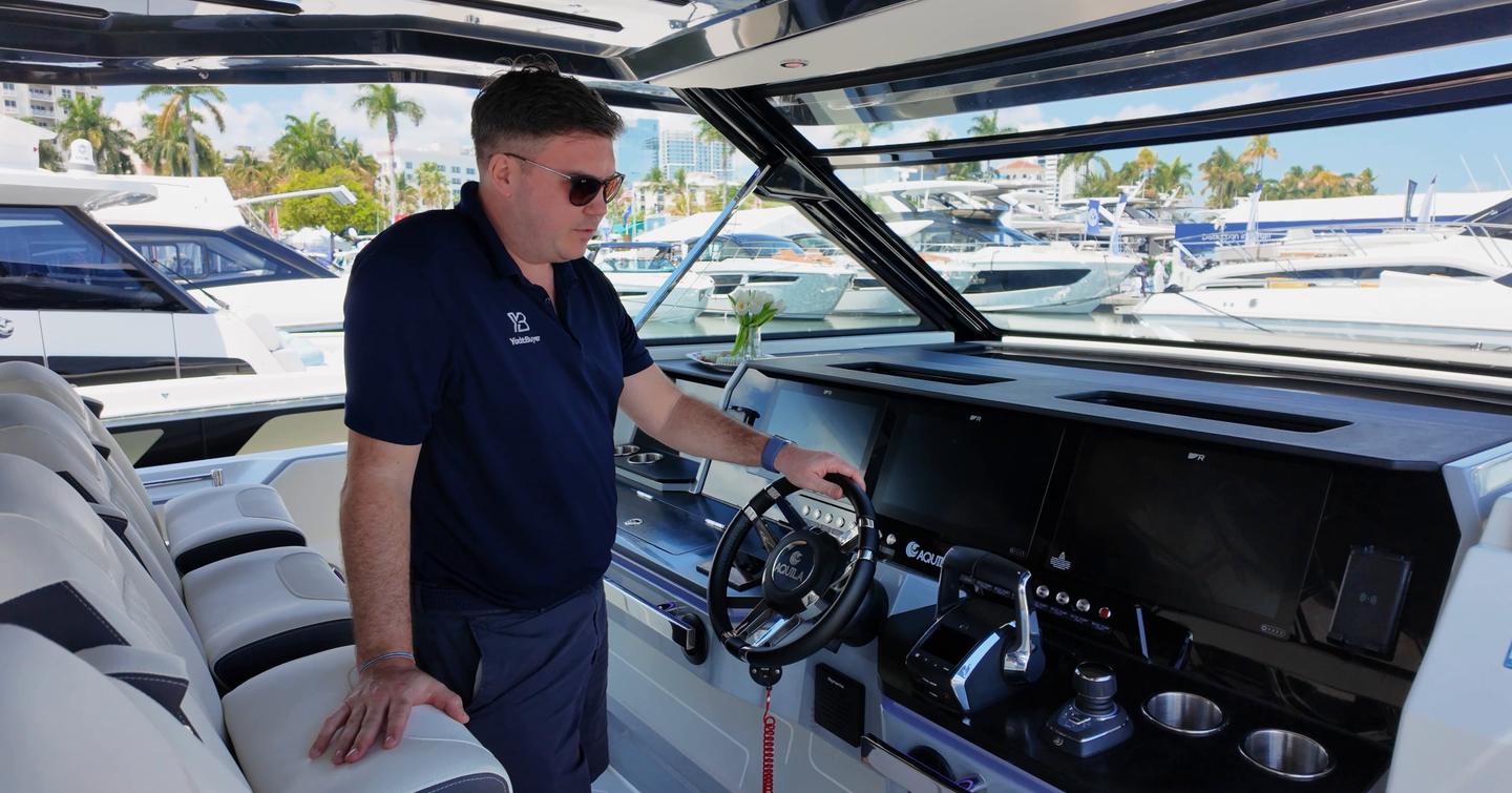 Aquila 45 Sport helm station with Jack Haines at controls, showing twin displays, joystick and four-seat driving layout