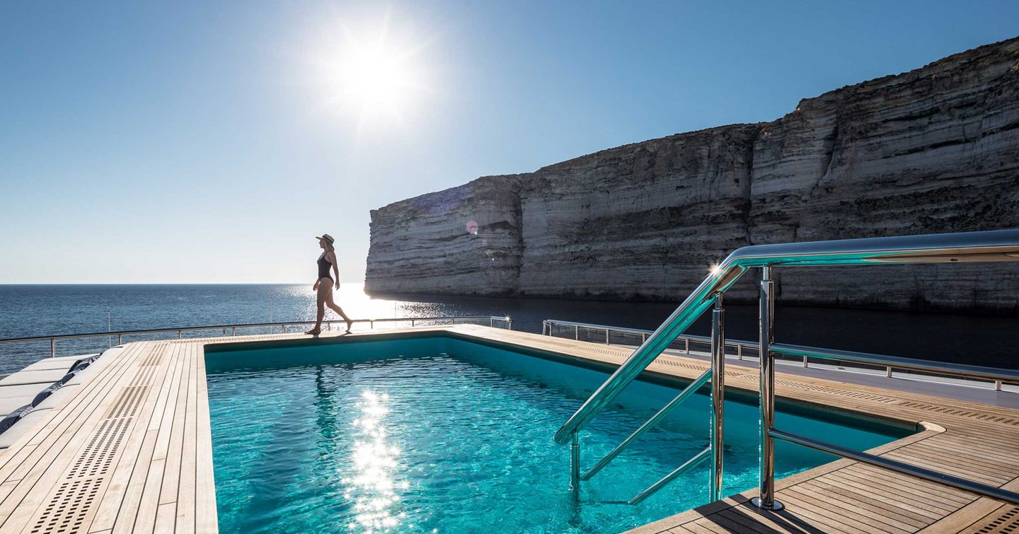 Woman walking on Superyacht Mar aft deck pool 