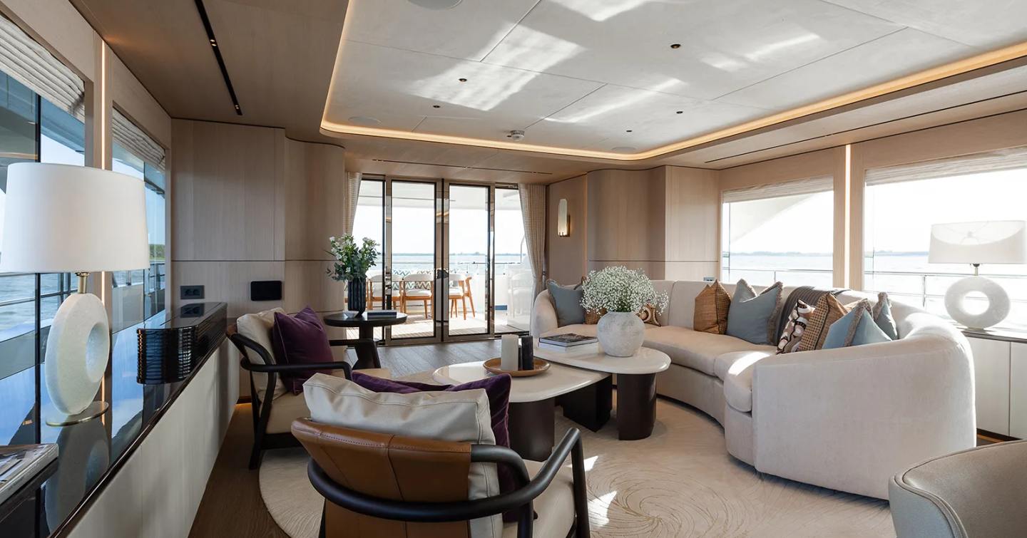 Superyacht Mustique's main saloon with curved sofa and coffee table