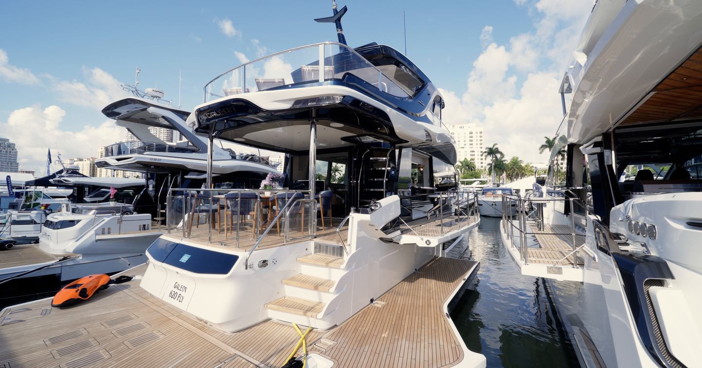 Stern view of the Galeon 620 Fly with fold-down terraces and beach-club layout deployed alongside the dock.