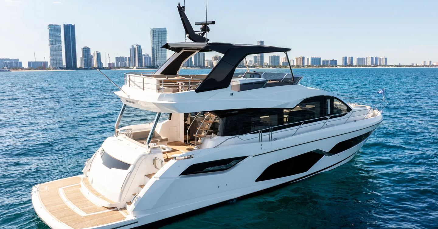 Motor yacht Manhattan 68 at anchor, with cityscape behind 