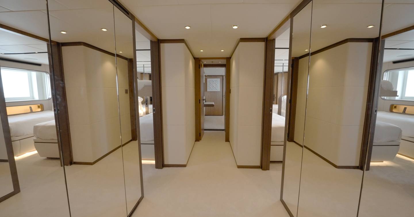 Lower deck guest lobby aboard the Gulf Craft Majesty 145 with mirrored wardrobes and access to five guest cabins