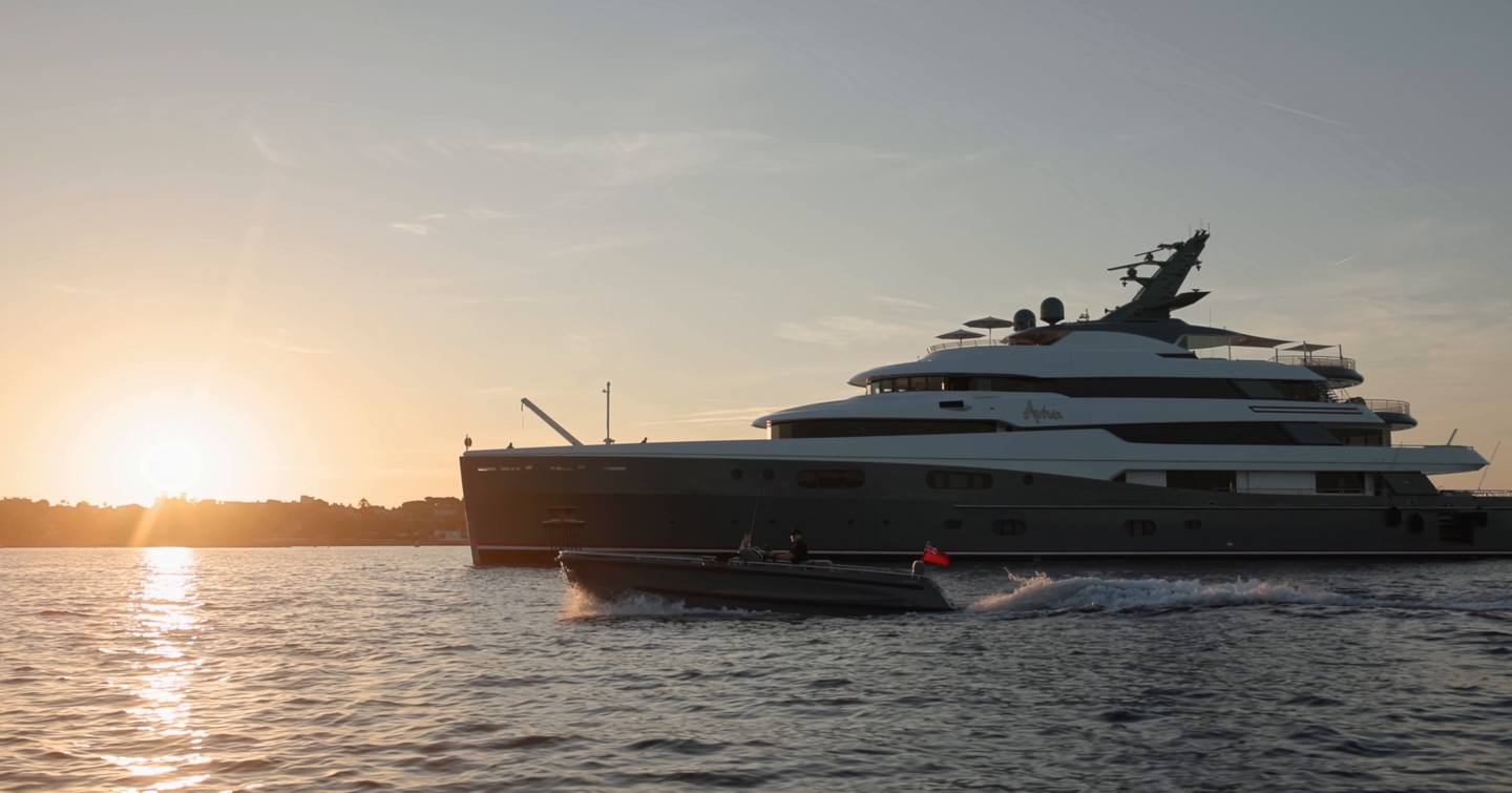 Evene Origin 71 superyacht tender underway beside a superyacht at sunset
