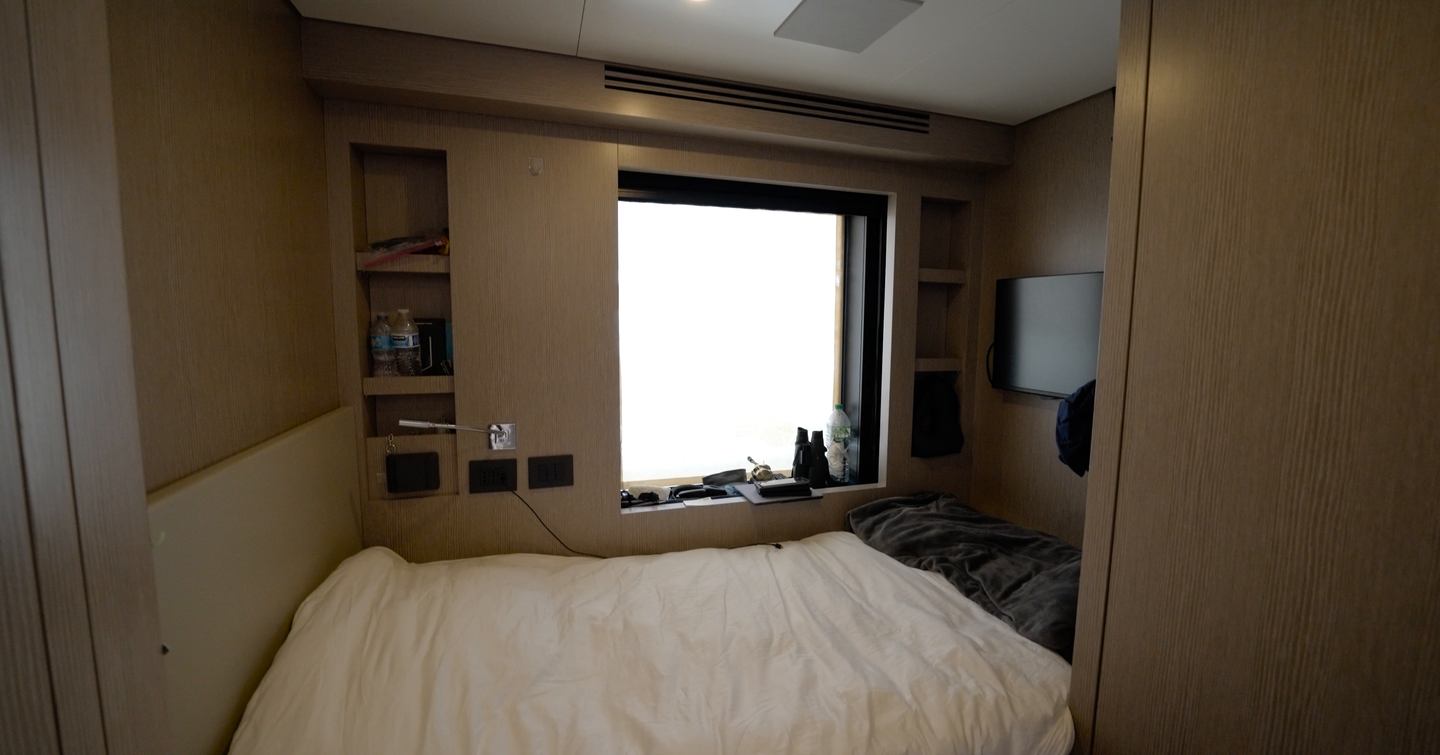 Benetti Oasis 34M captain's cabin with double berth, hull-side window, television and built-in storage.
