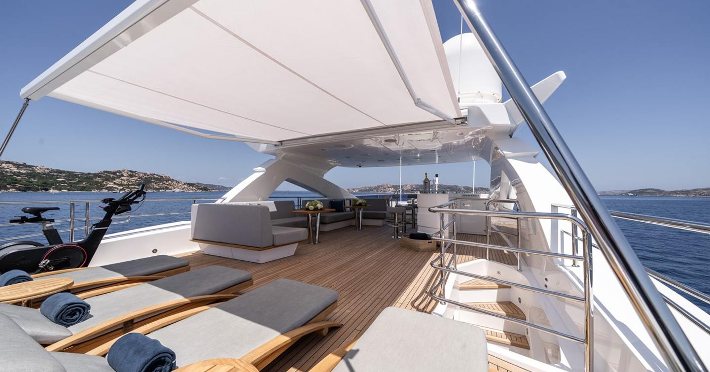 Superyacht Berco Voyager sundeck with shaded sunloungers and bar area