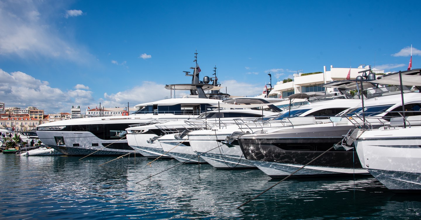 Cannes Yachting Festival shot taken at the 2024 show with bright blue sky and motor yachts moored stern to so the image shows their bows