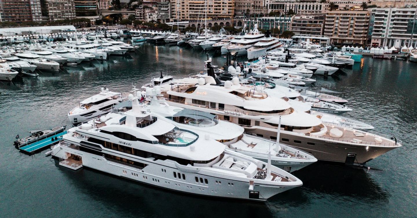 Elevated view of superyachts docked at Monaco Yacht Show, surrounded by hotels and marina facilities