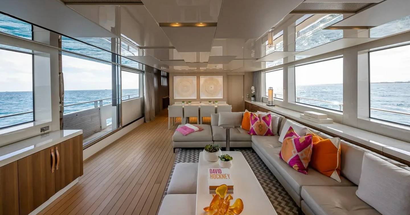 Motor yacht Xwave's main saloon with L-shaped sofa and dining area
