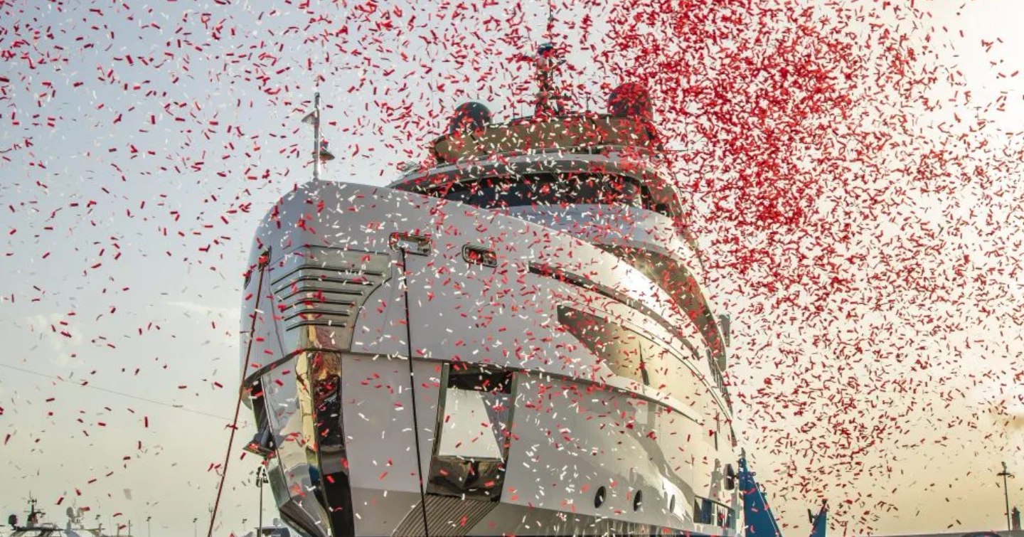 Frontal view of Benetti B.YOND 37m bow during launching ceremony, red confetti surrounds superyacht.