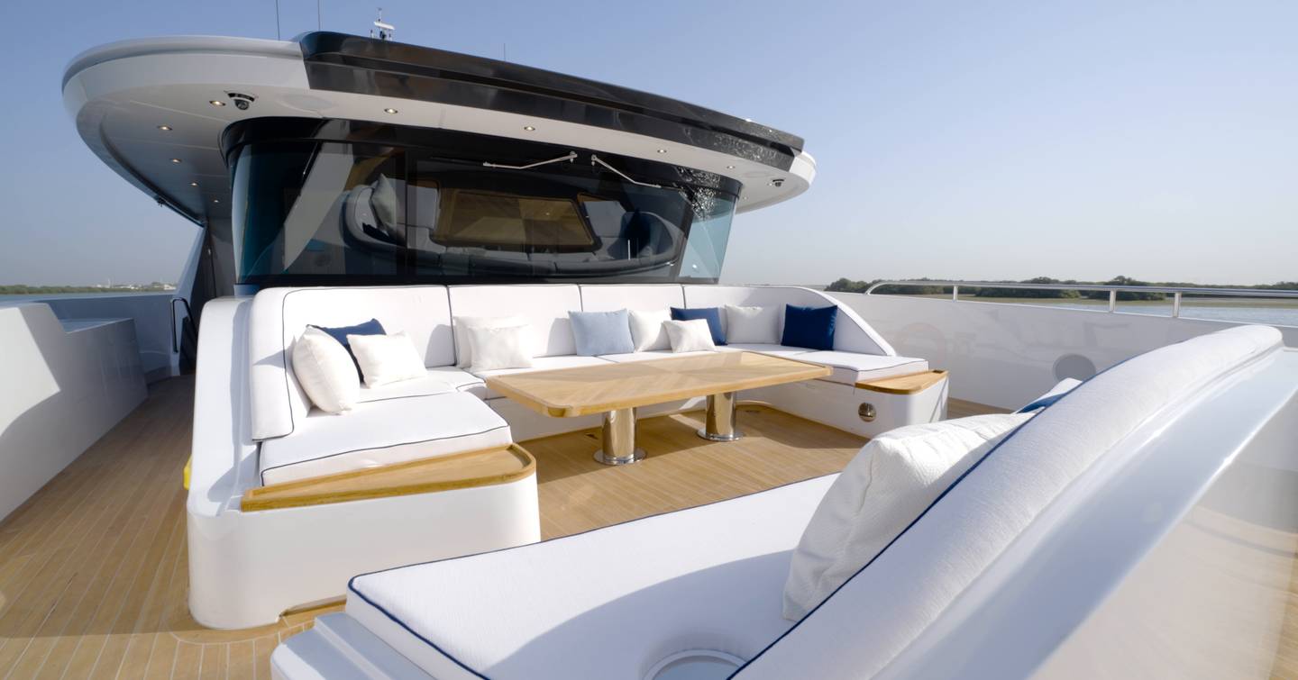 Foredeck lounge aboard the Gulf Craft Majesty 145 with U-shaped seating and dining table