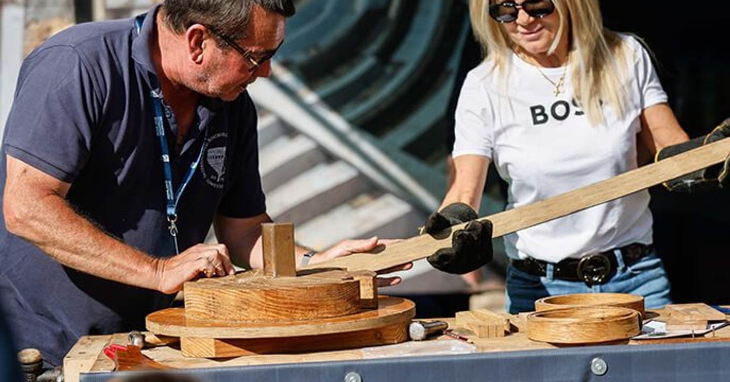 Two demonstrators at the Southampton International Boat Show showing boat building skills.