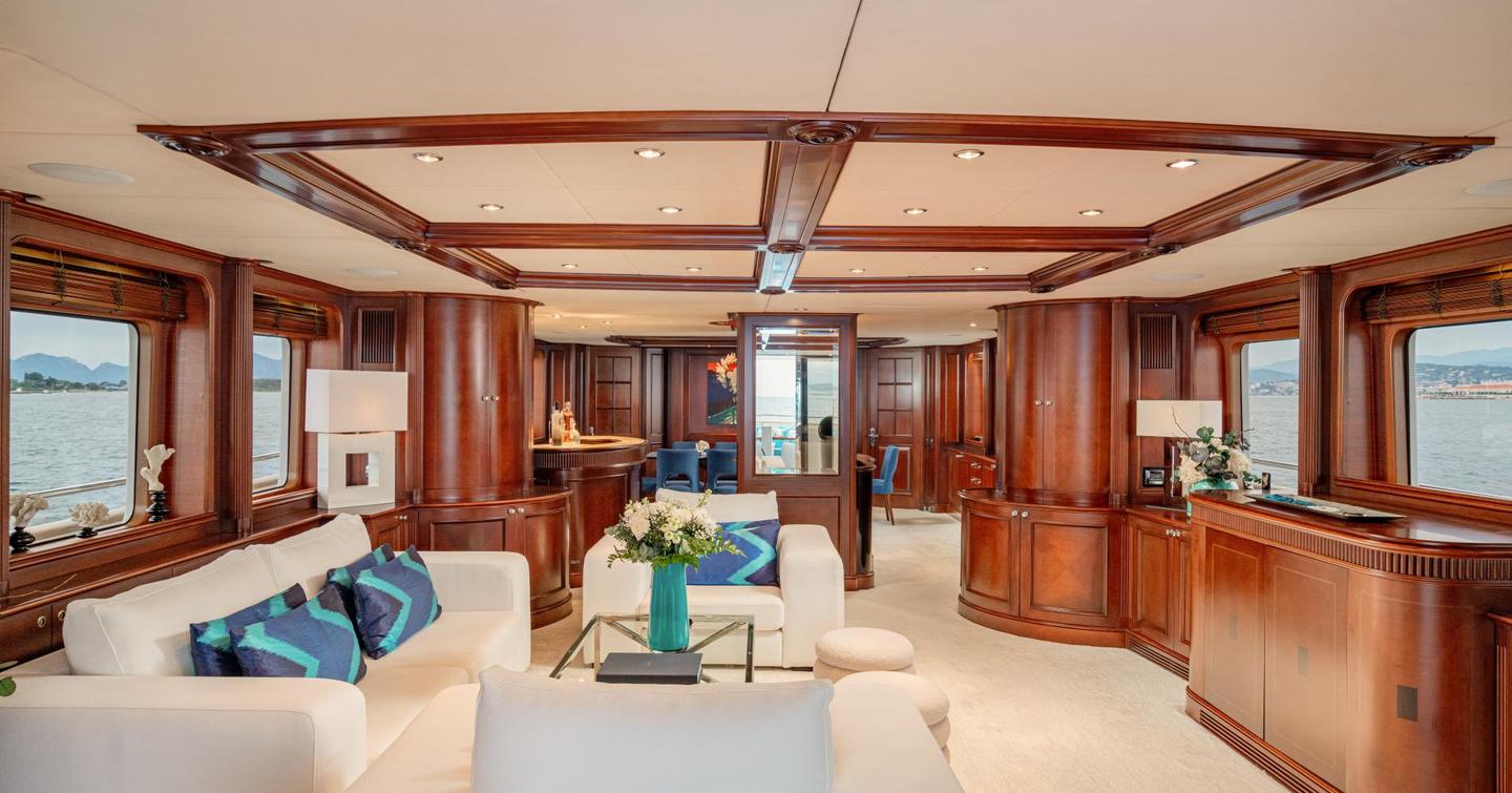 Superyacht Bang! main saloon with dark wooden features and white sofa