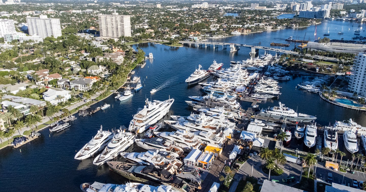 Aerial view of Fort Lauderdale during FLIBS. Many yachts berthed in marinas, surrounded by high-rise buildings.