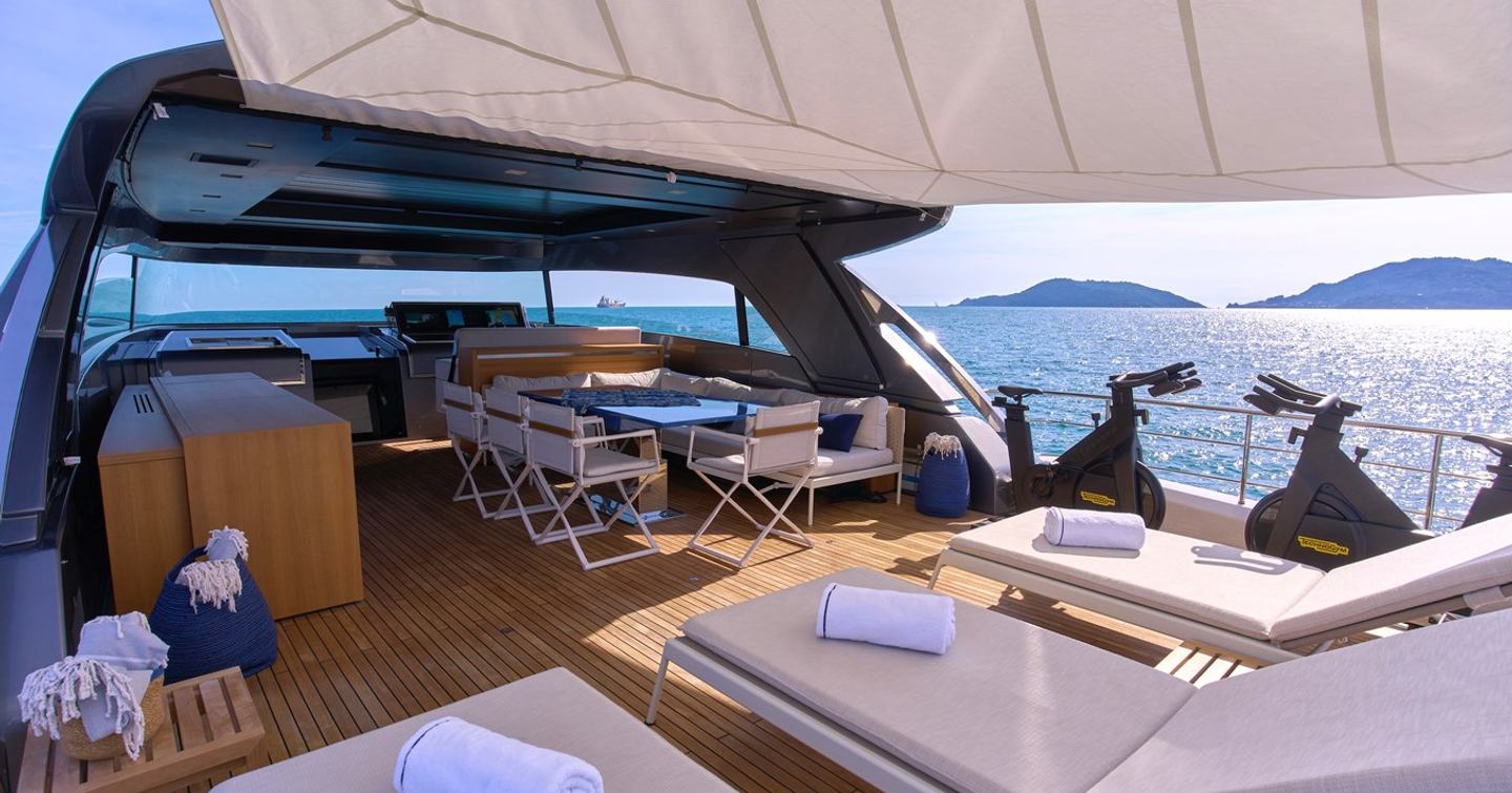 Motor yacht Estia's flybridge with alfresco dining, helm station and sunpads