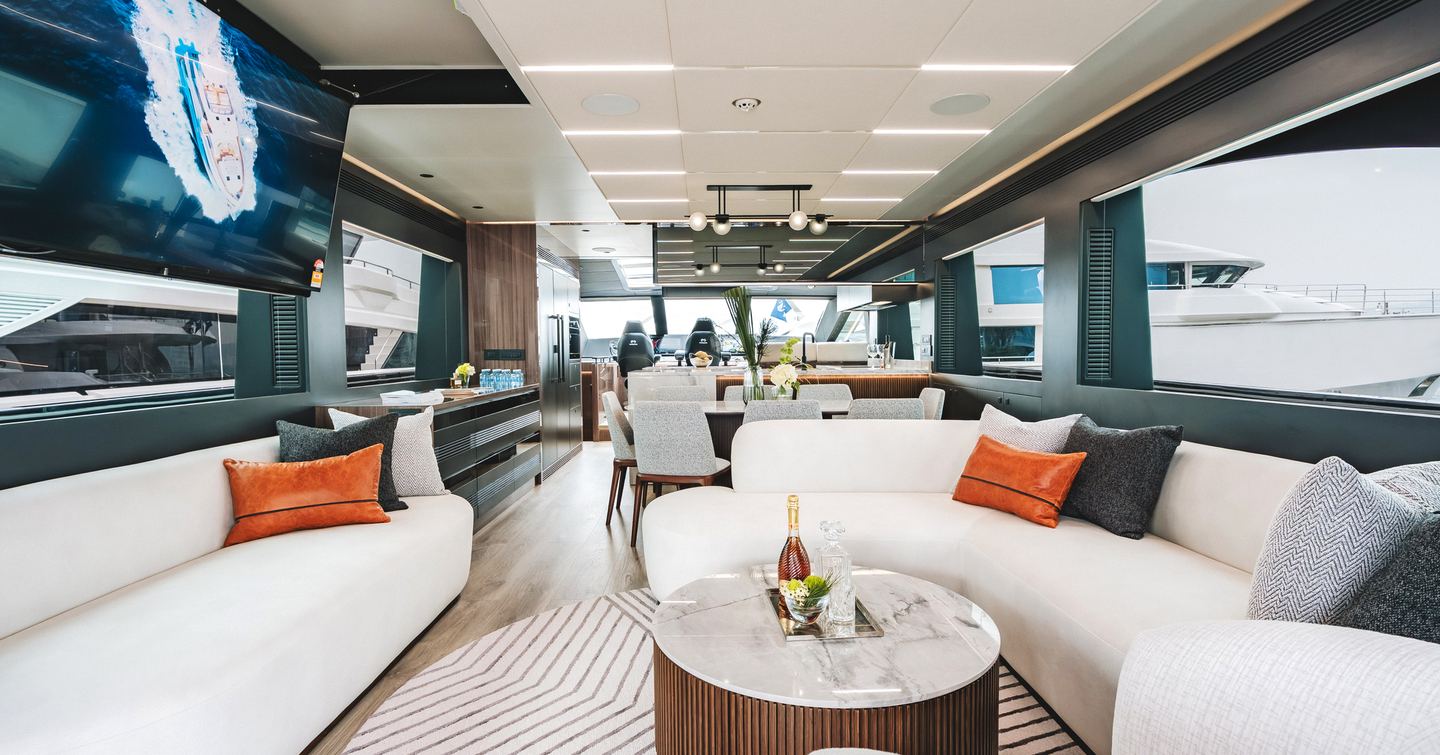 Horizon ES88 Sport Yacht KeΦi main salon with curved white seating and fold down TV
