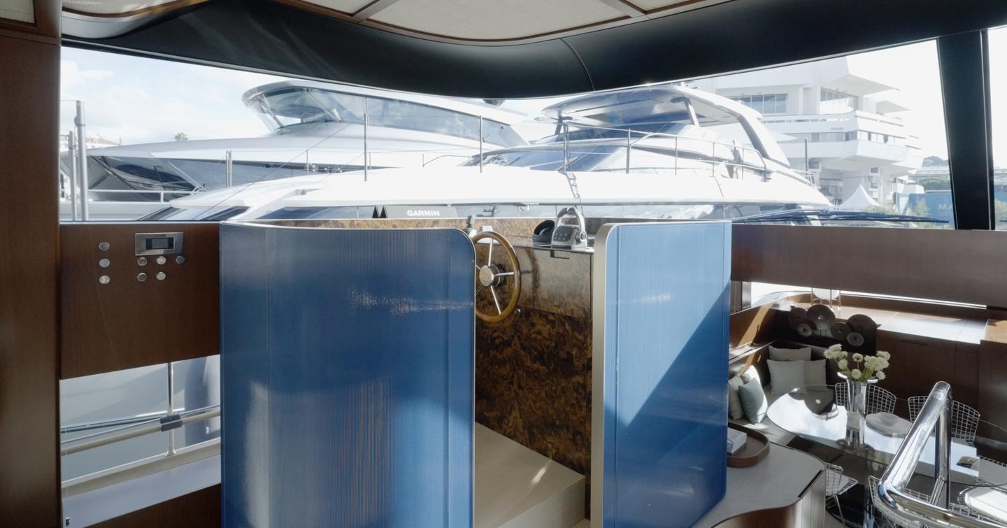 Sanlorenzo SHE helm station overlooking the lower dining area with curved windscreen