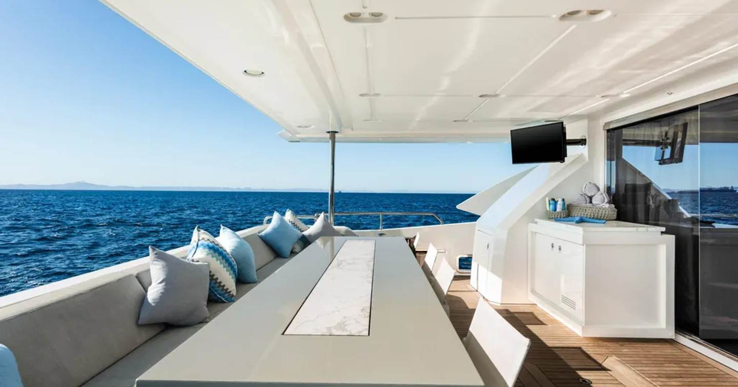 Superyacht Indigo's main aft deck with alfresco dining and mounted TV
