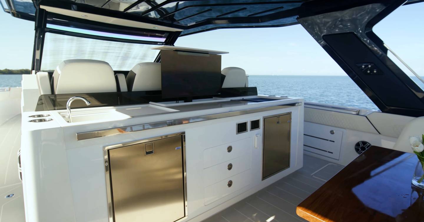 Aquila 45 Sport cockpit wet bar with sink, fridges and pop-up TV, showing outdoor galley setup under hardtop
