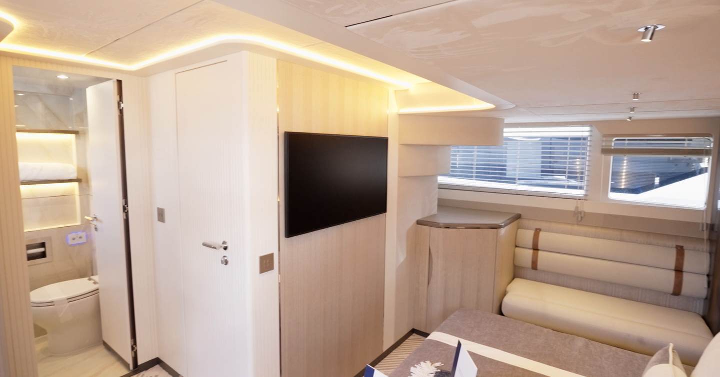 Interior view of the Galeon 620 Fly owner’s suite showing seating area, television and ensuite entrance.