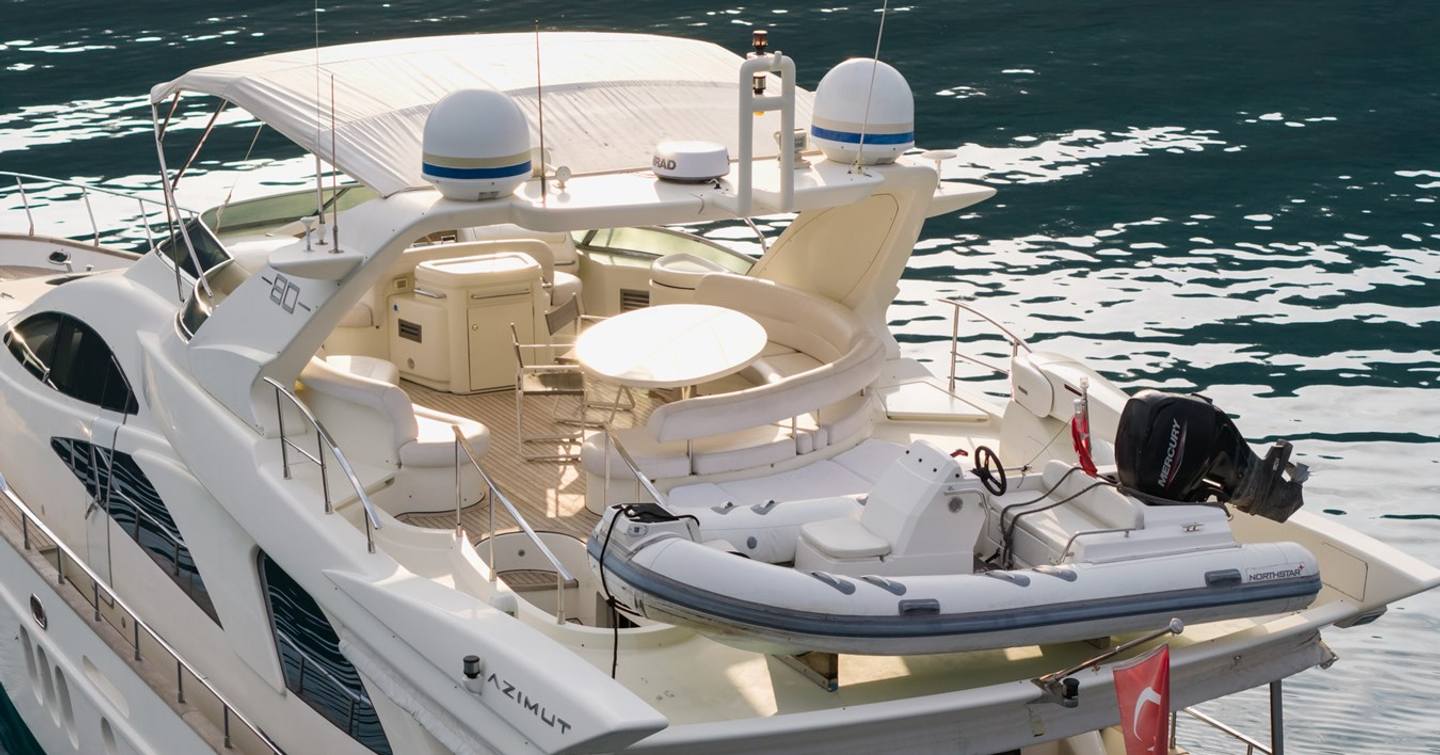 Motor yacht Senior S flybridge with curved white seating and tender 