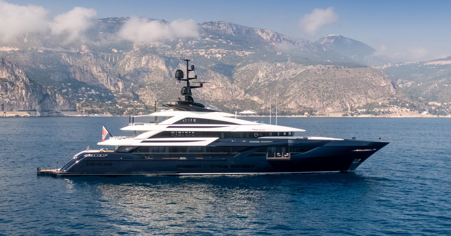 Motor yacht S5 at anchor against a mountainous backdrop