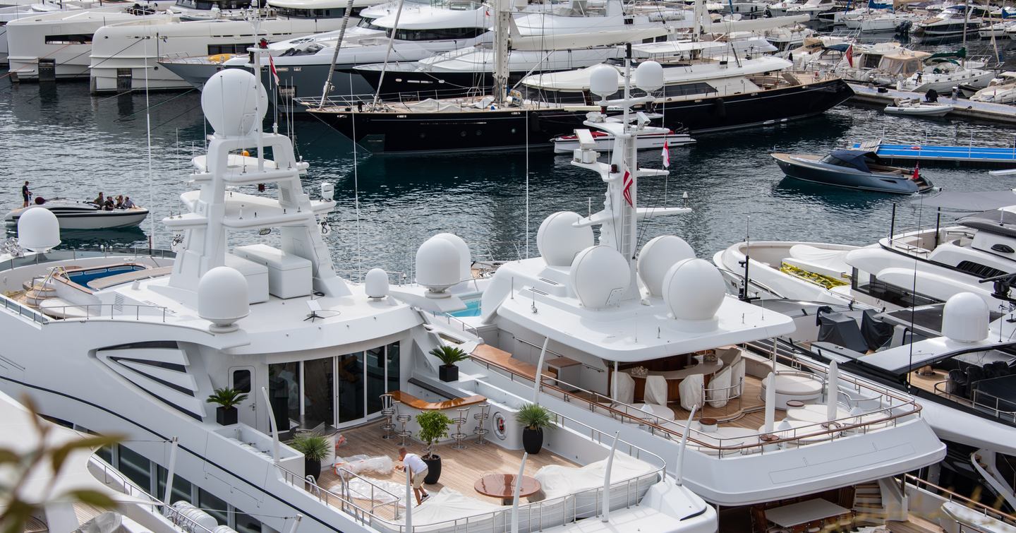 Aft overview of superyachts berthed at Port Hercule during the Monaco Yacht Show