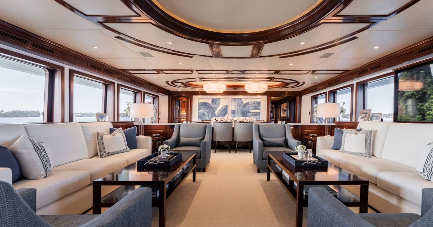 Superyacht Summer Dance main saloon with white and grey furniture and wooden coffee tables