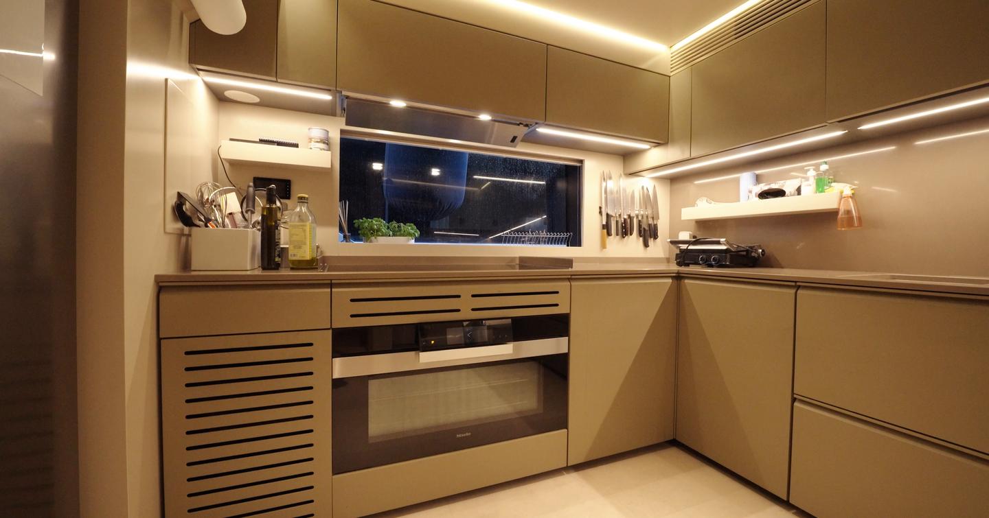 Custom Line Navetta 38 galley on main deck with induction cooktop, oven, storage and window for natural light