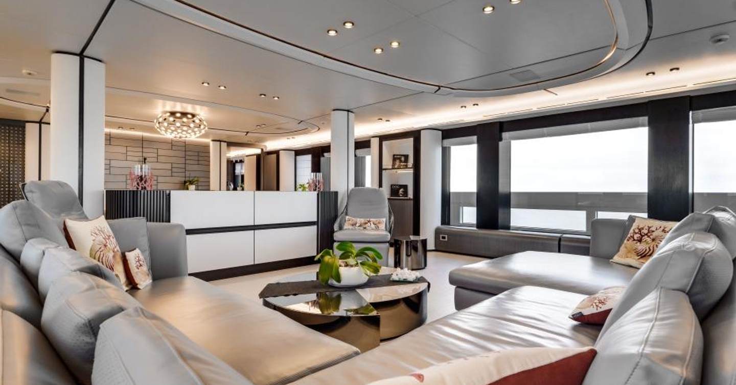 Superyacht L.A.U.L. main saloon with grey seating and glossy coffee table