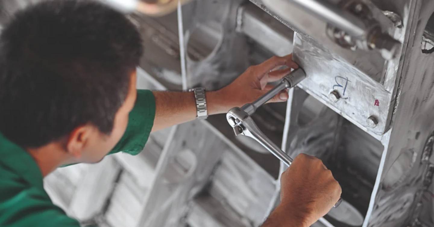 Man working on a superyacht with a ratchet 