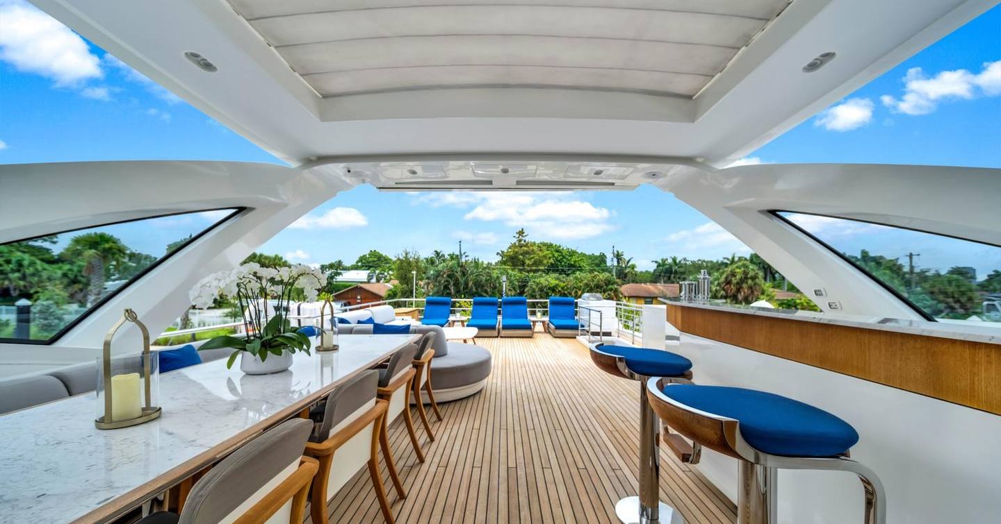 Superyacht One & Only sundeck with blue deck chairs, alfresco dining and blue bar stools