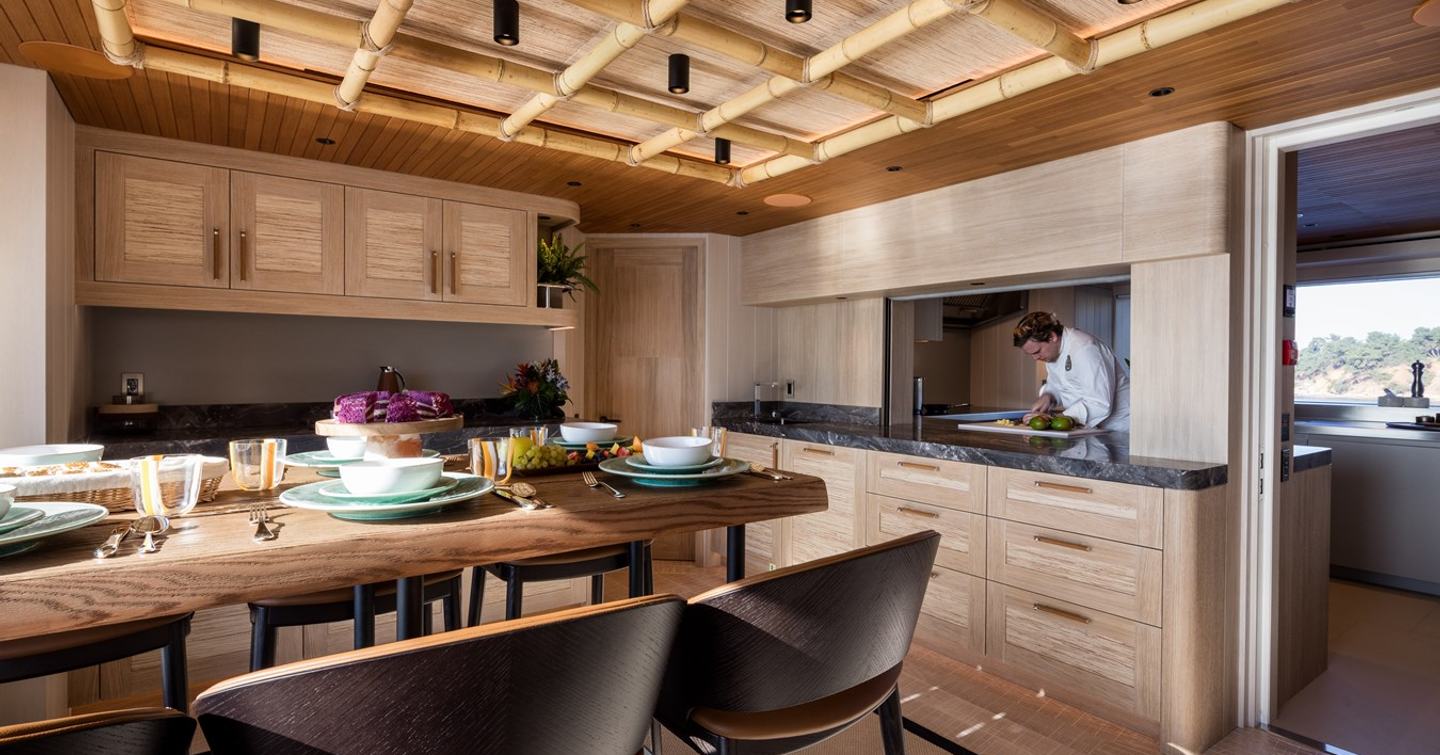 Motor yacht King Benji's breakfast nook with open galley and wood detailing
