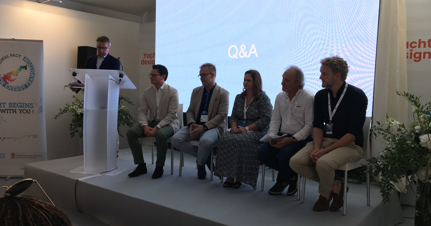 Panel of speakers seated on stage at Monaco Yacht Show during a question and answer session at the Sustainability Conference.