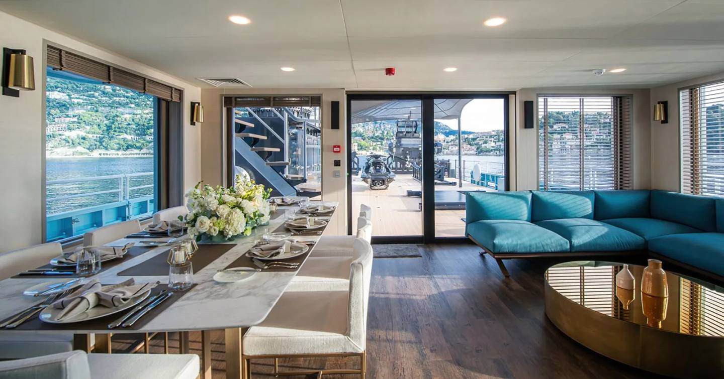 Support yacht Five Oceans interior with blue furnishings and dining area